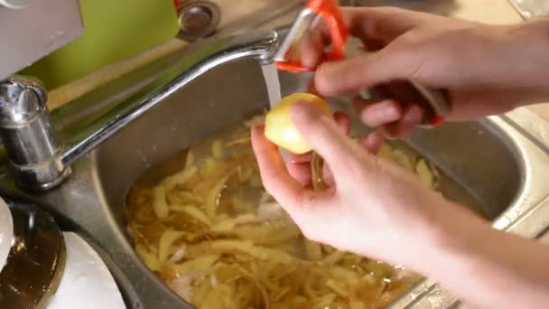 Mãos Masculinas Descascando Batatas Cruas Com Uma Faca Pia Com — Vídeo de Stock