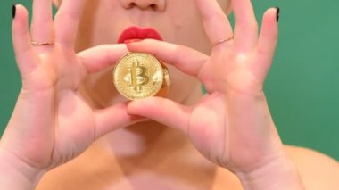 Kız bir bitcoin para bulanık chroma anahtar arka plan üzerinde cryptocurrency, tutar..