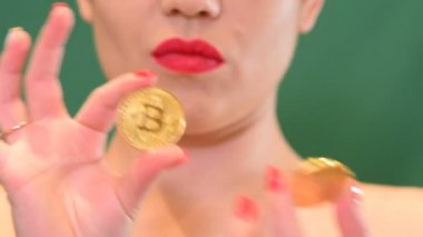Kız bir bitcoin para bulanık chroma anahtar arka plan üzerinde cryptocurrency, tutar..