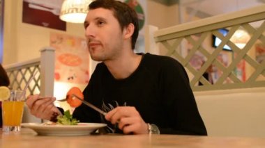 Restoran ve yiyecek salata içinde oturan bir adam