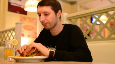 Bir adam bir restoranda bir Burger ve Limonata içer