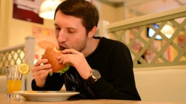 Bir adam bir restoranda bir Burger ve Limonata içer