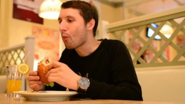 Bir adam bir restoranda bir Burger ve Limonata içer