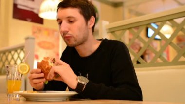 Bir adam bir restoranda bir Burger ve Limonata içer