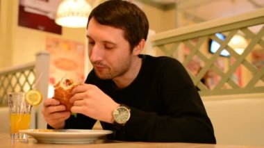 Bir adam bir restoranda bir Burger ve Limonata içer