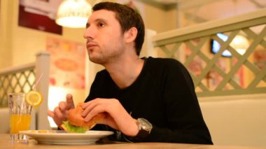 Bir adam bir restoranda bir Burger ve Limonata içer