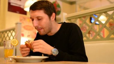 Bir adam bir restoranda bir Burger ve Limonata içer