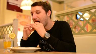 Bir adam bir restoranda bir Burger ve Limonata içer