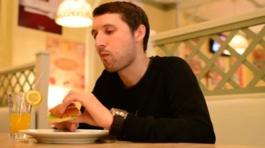 Bir adam bir restoranda bir Burger ve Limonata içer