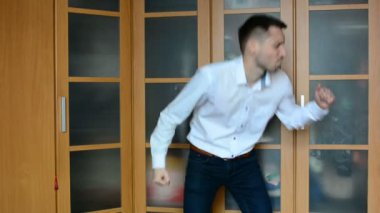 Genç bir adam evde bir dolap karşı dans