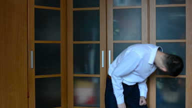 Genç bir adam evde bir dolap karşı dans