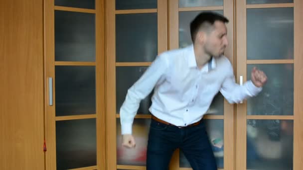 Een jongeman die dansen thuis tegen een kast — Stockvideo