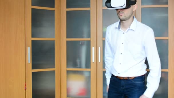 Homem vestindo fone de ouvido VR na sala de estar. Usando gestos com as mãos . — Vídeo de Stock