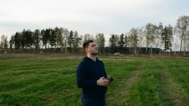 Genç adam kontrol dron batımında alanındaki.