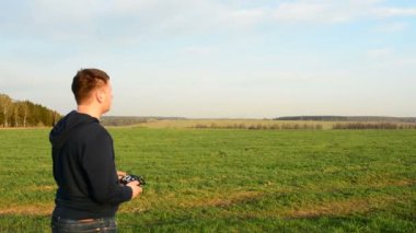 Genç adam kontrol dron batımında alanındaki.