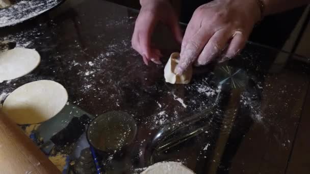 在厨房桌子上用滚针把面团卷出来 放在一个薄蛋糕里做饺子 — 图库视频影像