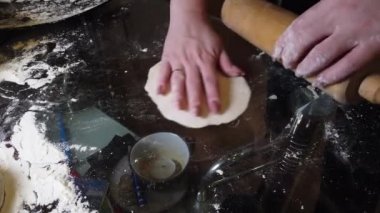 Kadın masaya hamura biraz un ekler. Adım adım ev yapımı hamur köftesi rehberi.