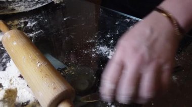 Kadın masaya hamura biraz un ekler. Adım adım ev yapımı hamur köftesi rehberi.