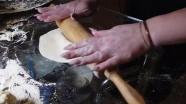 Kadın masaya hamura biraz un ekler. Adım adım ev yapımı hamur köftesi rehberi.