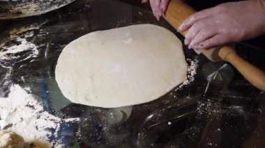 Kadın masaya hamura biraz un ekler. Adım adım ev yapımı hamur köftesi rehberi.