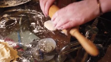 Kadın masaya hamura biraz un ekler. Adım adım ev yapımı hamur köftesi rehberi.