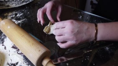 Kadın masaya hamura biraz un ekler. Adım adım ev yapımı hamur köftesi rehberi.