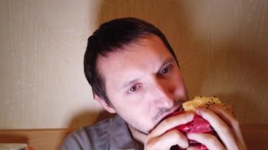 Hamburger yiyen adam. yakın çekim. Fast food yer. Burger yiyen adamın yakın çekim.