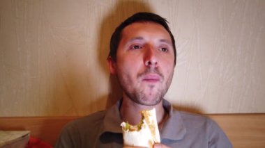 Hamburger yiyen adam. yakın çekim. Fast food yer. Burger yiyen adamın yakın çekim.