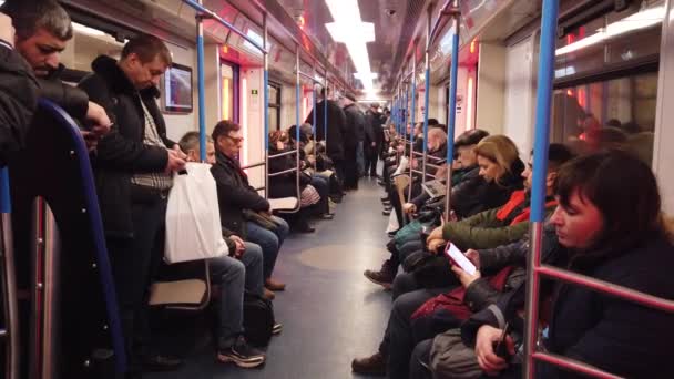 MOSCÚ, RUSIA - 12 DE DICIEMBRE DE 2019: Personas en el vagón del metro. Metro de Moscú. Los pasajeros se sientan en lugares con diferentes actividades . — Vídeo de stock