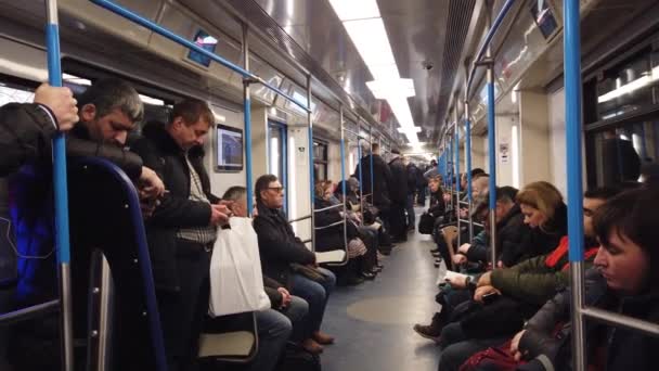 モスクワ、ロシア- 12 12月2019:地下鉄の車の中で人々。モスクワ地下鉄。乗客はさまざまな活動の場所に座っています. — ストック動画