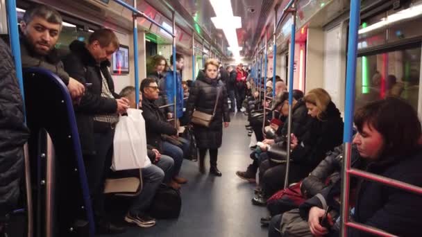 Moskva, Rusko - 12. prosince 2019: Lidé v podzemním voze. Moskevské metro. Cestující sedí v místech s různými aktivitami. — Stock video