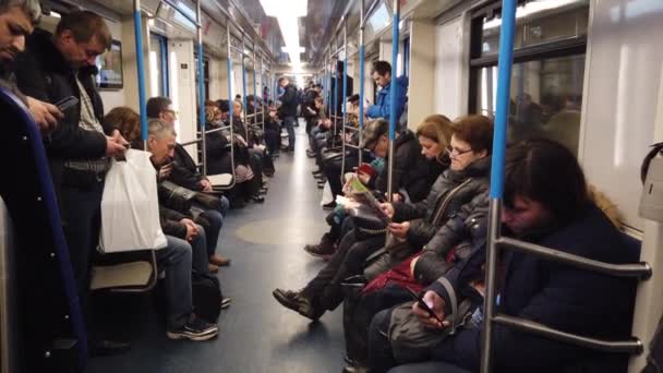 Moskau, Russland - 12. Dezember 2019: Menschen in der U-Bahn. Moskauer U-Bahn. Passagiere sitzen an Orten mit unterschiedlichen Aktivitäten. — Stockvideo