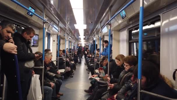 モスクワ、ロシア- 12 12月2019:地下鉄の車の中で人々。モスクワ地下鉄。乗客はさまざまな活動の場所に座っています. — ストック動画