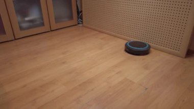 Robot elektrikli süpürge evin etrafında dönüyor, elektronik aletlerle evi temizliyor.