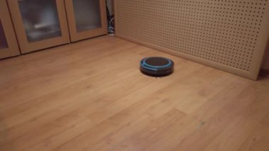 Robot elektrikli süpürge evin etrafında dönüyor, elektronik aletlerle evi temizliyor.