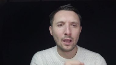 Koruyucu maskeli bir adam öksürüyor. Adam hasta, üşütmüş, öksürüyor..