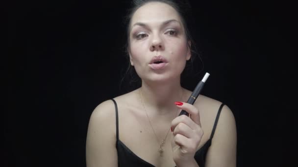 Primer plano mujer bonita con cigarrillo electrónico IQOS. Mujer joven fumando tabaco palo calefacción y humo de escape . — Vídeos de Stock