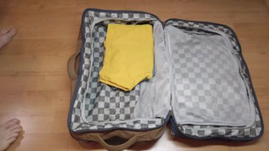 Tatil ve iş seyahati için bavul toplayan bir adam.