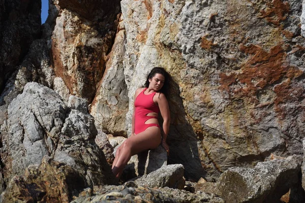 Tayland 'ın masmavi denizinin kayalık sahillerinde bir kız.