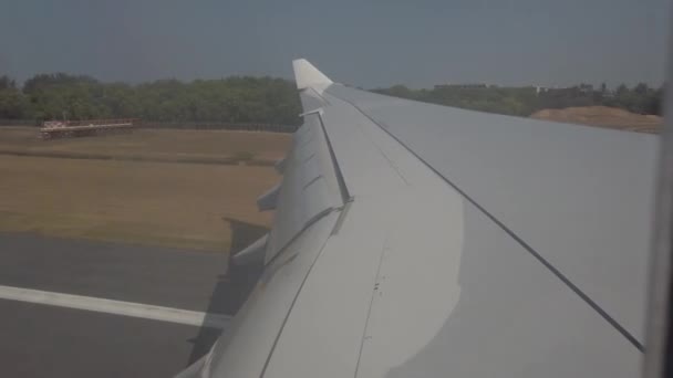 Plano asa close-up, avião vai para terra no aeroporto de Phuket — Vídeo de Stock
