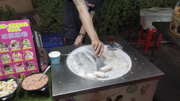 01 марта 2020, Патонг, Таиланд: В Таиланде, человек делает мороженое на поверхности для льда, приготовление тайского мороженого — стоковое видео