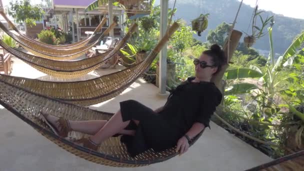 Uma Linda Garota Morena Relaxa Enquanto Está Deitada Uma Rede — Vídeo de Stock