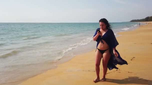 Krásná Brunetka Kráčí Dlouhé Opuštěné Pláži Dívá Svého Telefonu — Stock video
