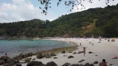 11 Mart 2020, Özgürlük Sahili, Phuket, Tayland: Beyaz kum ve turkuaz berrak su, uzun kuyruklu tekneler ve güneşlenen insanlar ile güzel tropikal plajdan manzara.