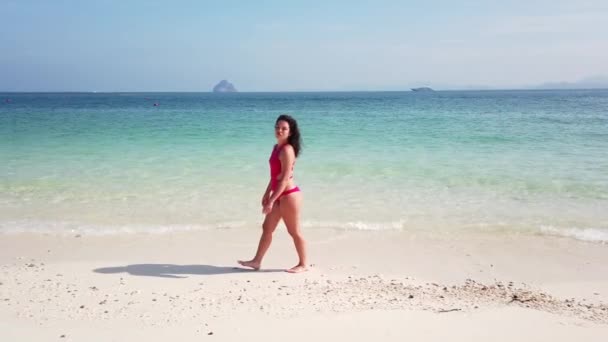 Fille brune marche sur la plage d'une île inhabitée avec de l'eau azur 
