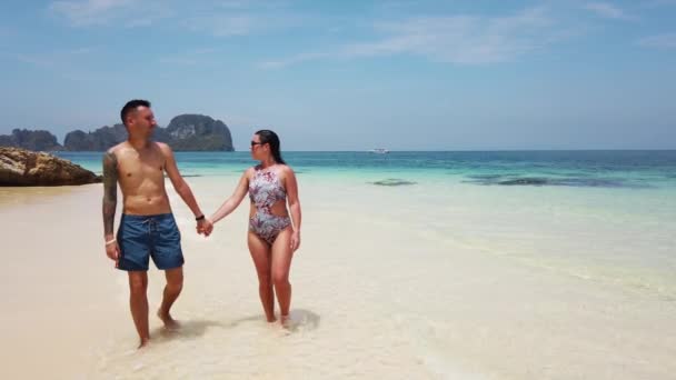 Una Pareja Enamorada Pasea Por Una Playa Con Agua Azul — Vídeos de Stock