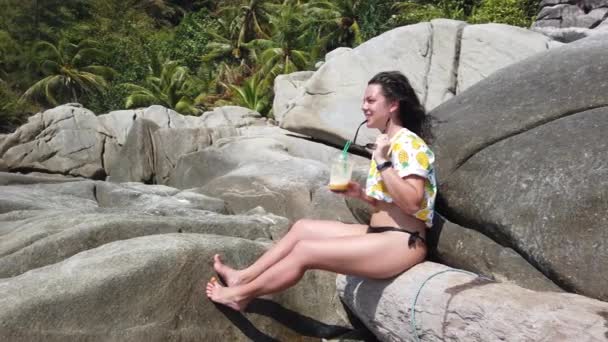 Uma Menina Bebe Frutas Frescas Praia Sentada Uma Grande Pedra — Vídeo de Stock