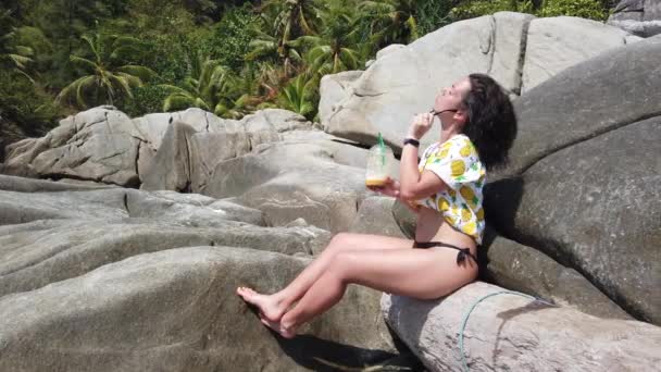 Ein Mädchen Trinkt Frisches Obst Strand Sitzend Auf Einem Großen — Stockvideo