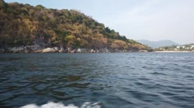 Tekne, büyük taşların yattığı kıyıda savruluyor.