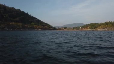 Tekne, büyük taşların yattığı kıyıda savruluyor.